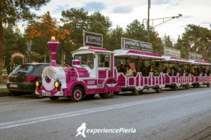 People riding a pink mini train in Litochoro park, Pieria