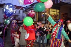 people and clowns hold balloons during Apokries The Greek Carnival in Litochoro, Pieria, Greece