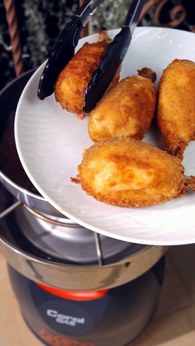 Cheesy chicken drumstick poppers being fried to golden perfection