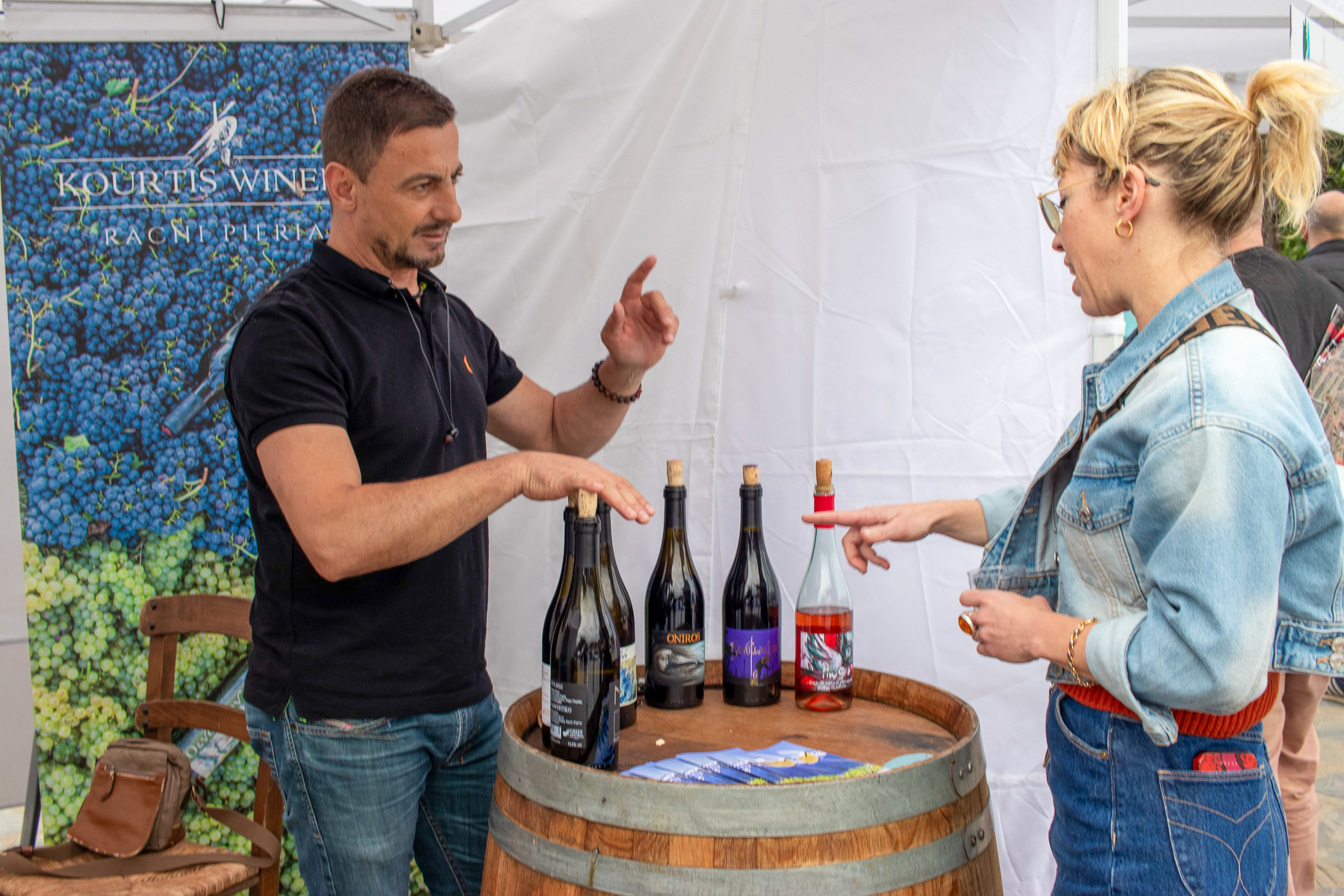 Kourti wines stall — host explaining wine to visitor