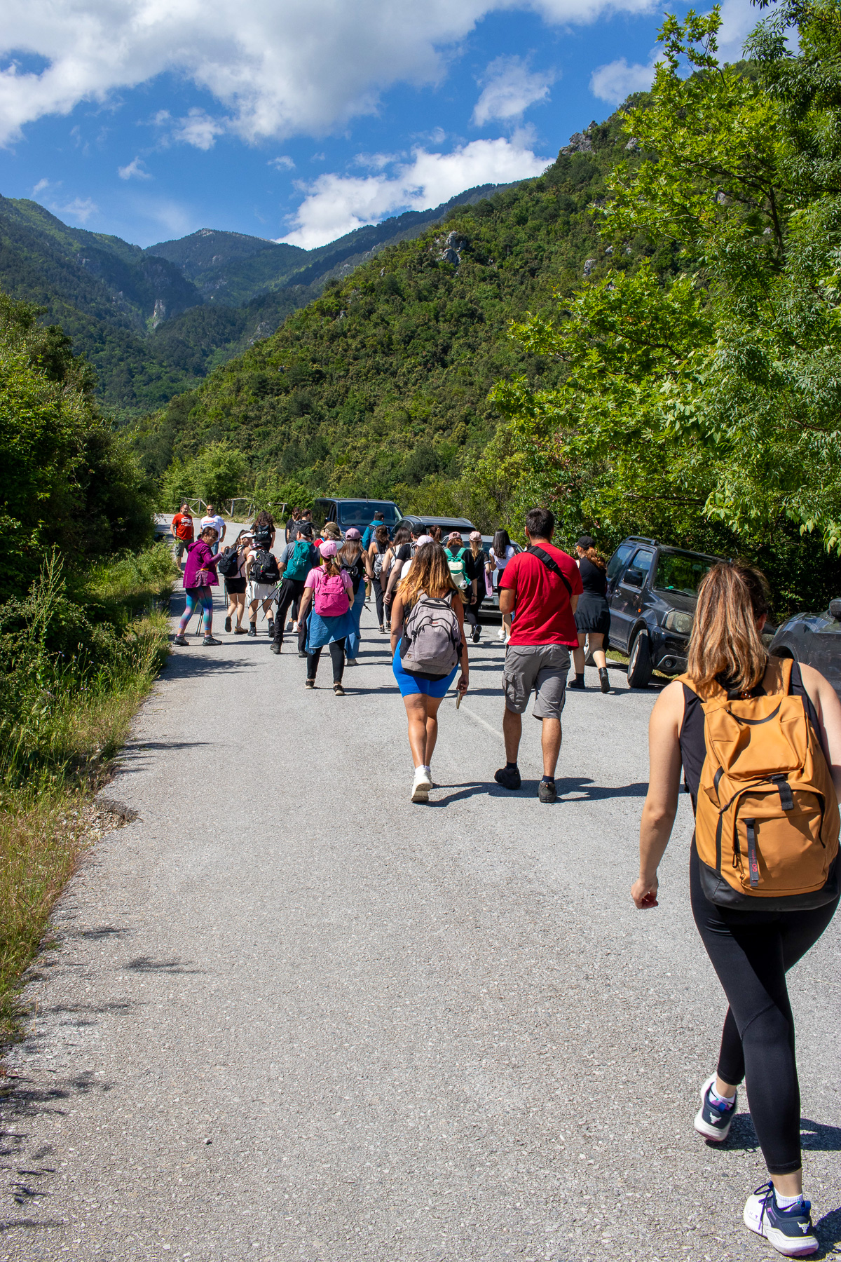 Crowd walking towards the Urlias waterfalls with Olympus peaks in background