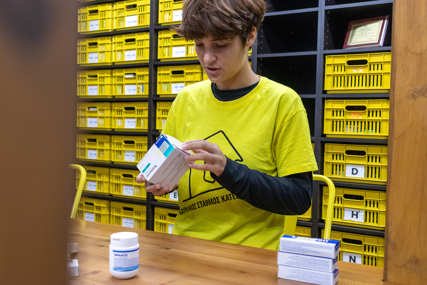 Close-up of Anna organizing medicine boxes in Kapnikos Stathmos, Pieria Greece