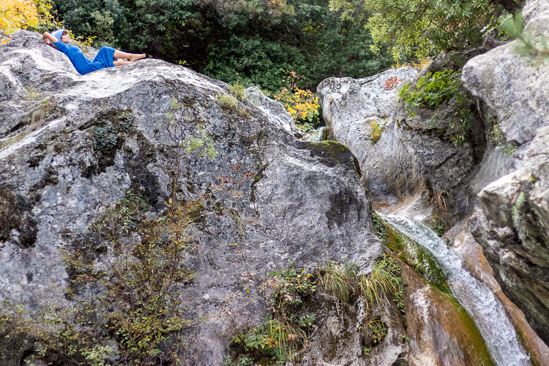 Anna barefoot on white rocks beside the Agia Kori waterfall, Pieria Greece