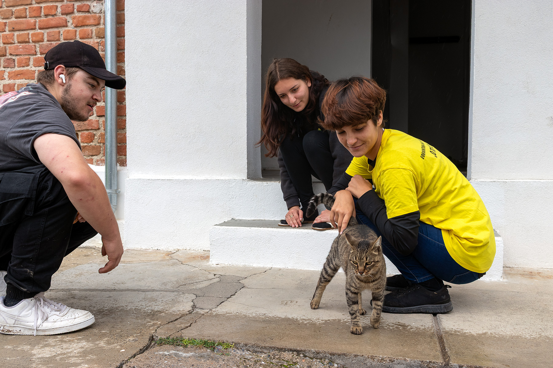 Anna and other volunteers petting a cat at Kapnikos Stathmos Katerini Pieria Greece