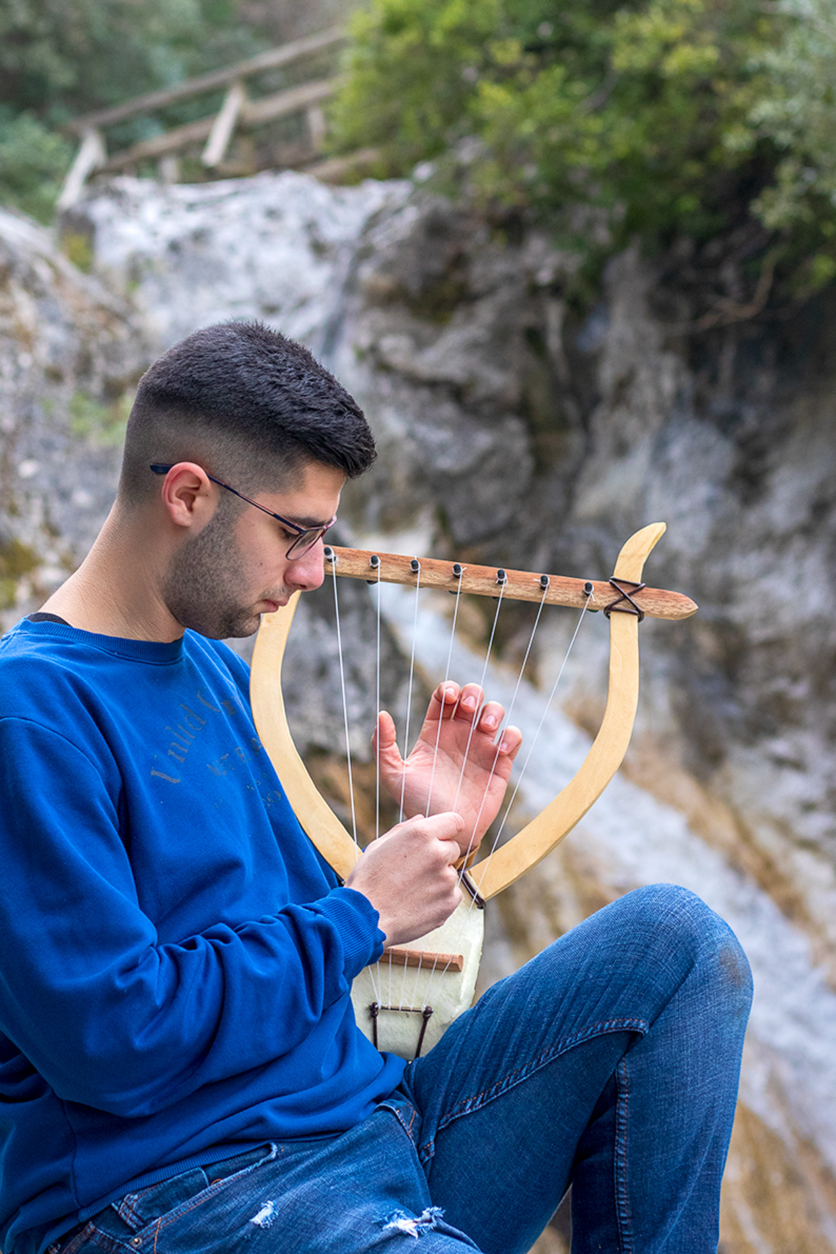 Christos Kyparissas with handmade ancient Greek lyra at Agia Kori waterfall, Olympus