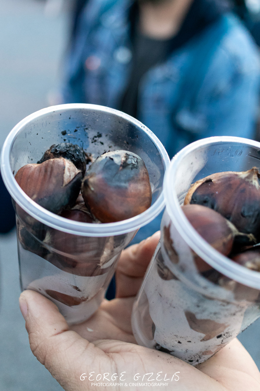 A serving of roasted chestnuts offered to visitors in a plastic cup at the Chestnut Festival in Skotina, Pieria, Greece.