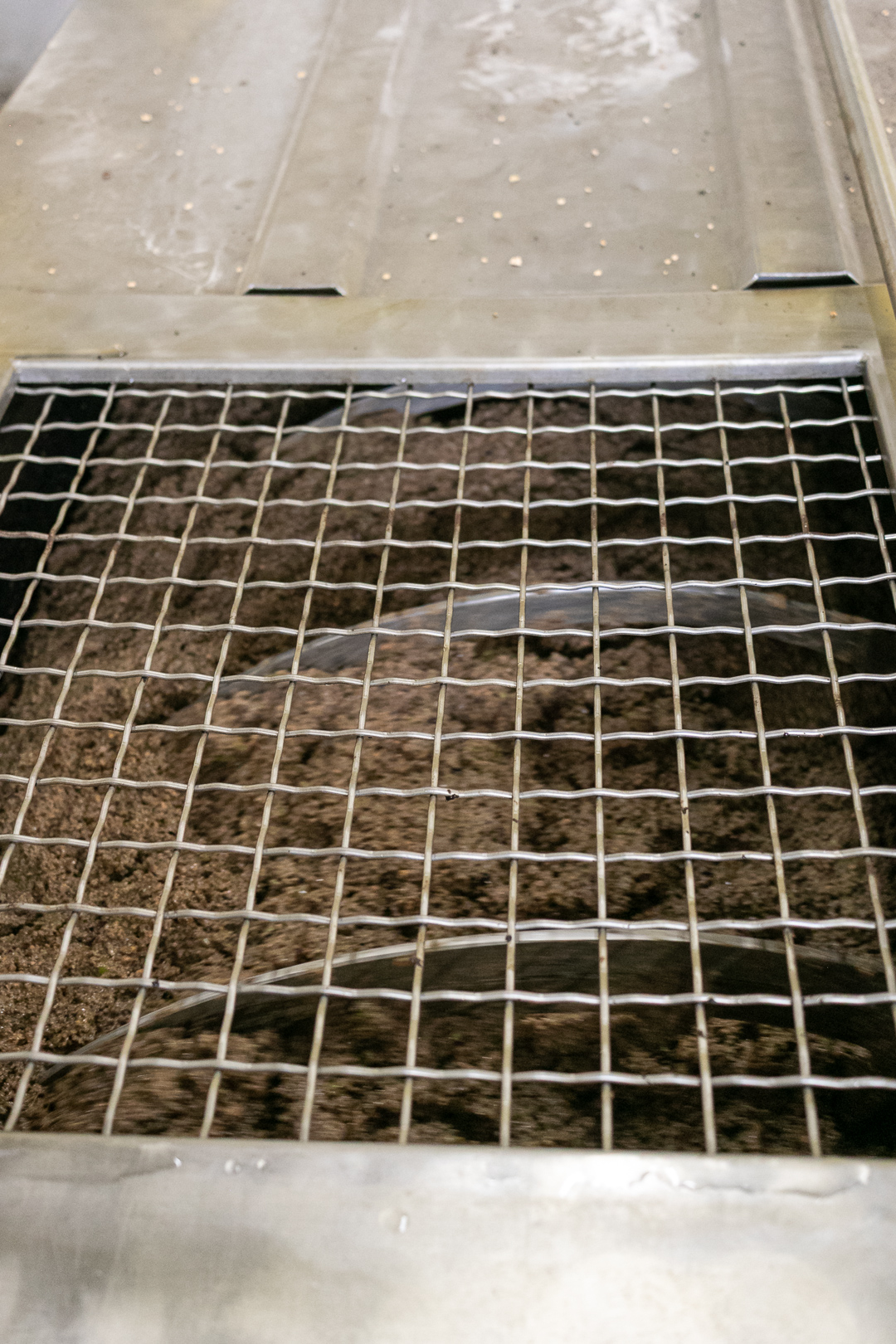 Stainless steel malaxer tanks used to slowly mix olive paste during olive oil production.
