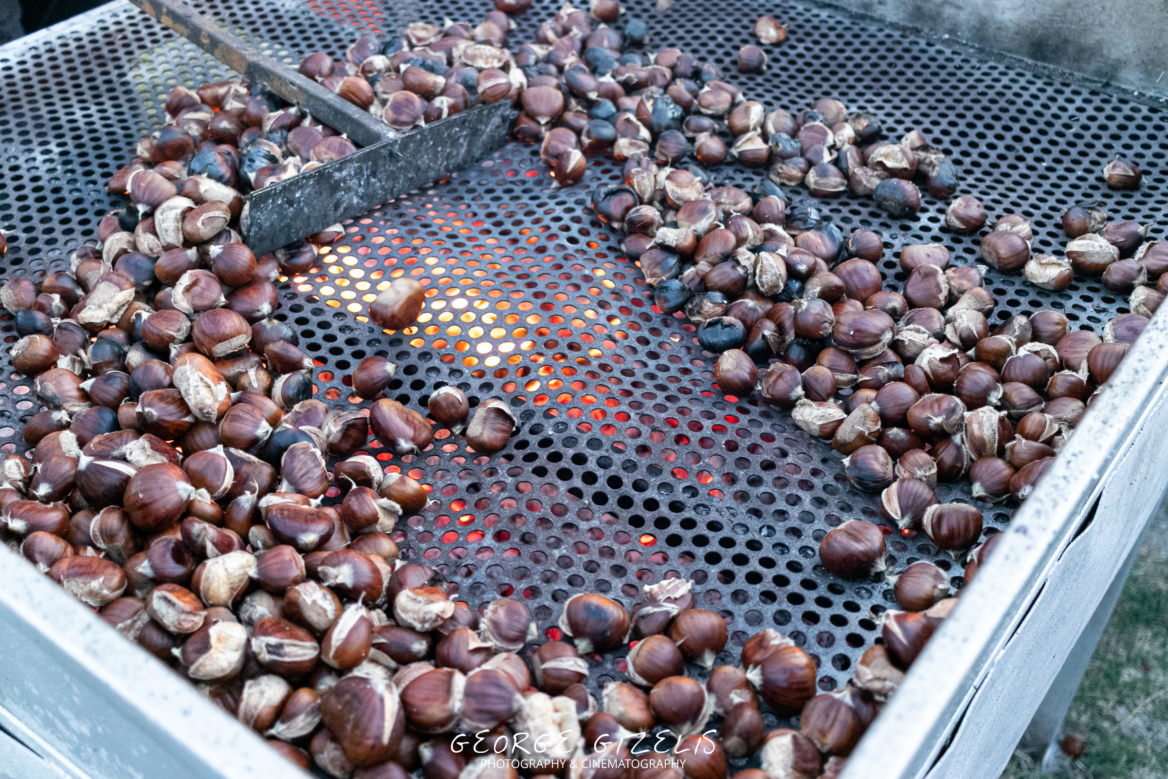 Chestnuts roasting over glowing embers at the Chestnut Festival in Skotina, Pieria, Greece.